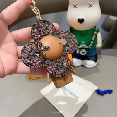 Taschenanhänger in Blütenform aus braunem Leder mit Bärenfigur