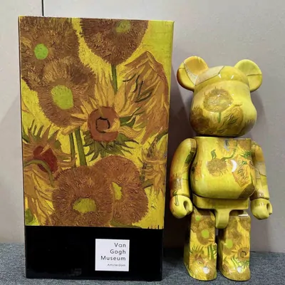 Designer-Bärenfigur mit Sonnenblumen-Motiv neben ihrer Verpackung
