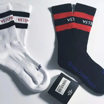 Zwei Sportsocken mit gesticktem Schriftzug, eine schwarz, eine weiß