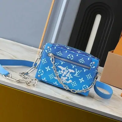 Blaue Schultertasche mit Monogrammmuster und Kettenriemen